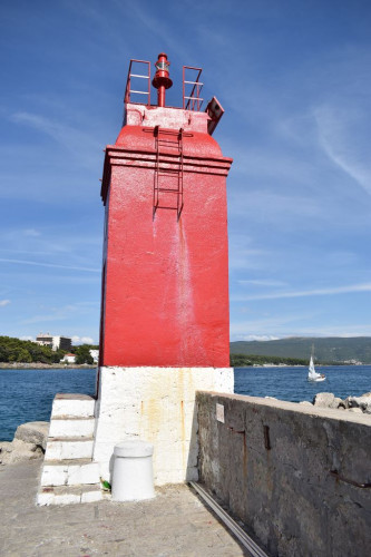 Breakwater's red port light, town of Krk